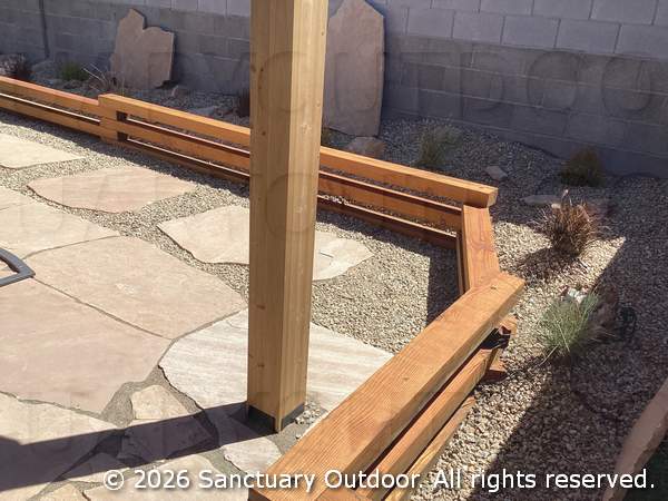 Timber border next to back yard pergola and flagstone with desert grasses and boulders