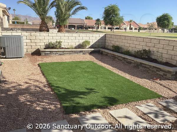 Back yard with decorative rock, turf, masonry planter, bird attracting natural plants, alternate view