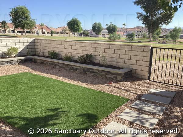 Back yard with decorative rock, turf, masonry planter, bird attracting natural plants, third view